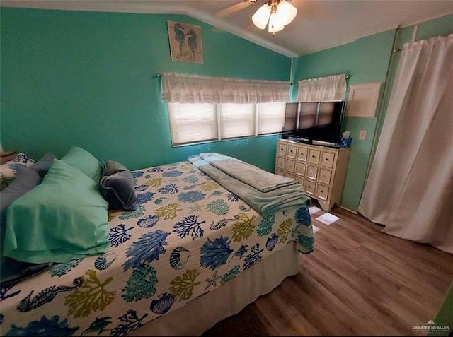 bedroom featuring ceiling fan, light hardwood / wood-style flooring, and lofted ceiling