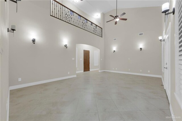 unfurnished living room with ceiling fan, high vaulted ceiling, and light tile patterned flooring