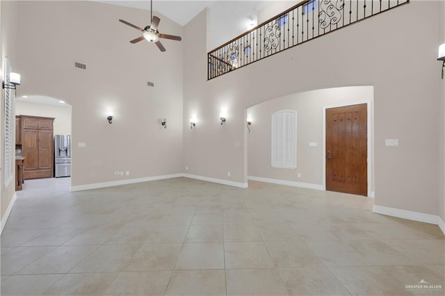 unfurnished living room with high vaulted ceiling, ceiling fan, and light tile patterned flooring