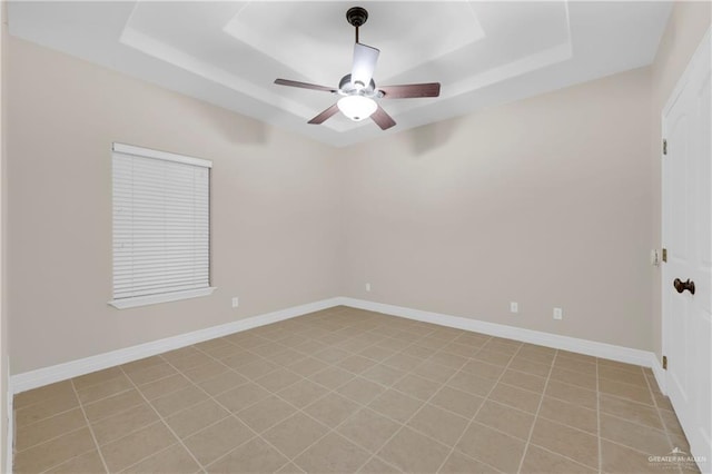 unfurnished room featuring ceiling fan and a raised ceiling