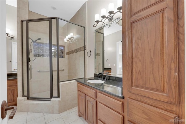 bathroom featuring tile patterned floors, a shower with door, and vanity