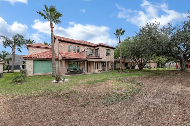 back of house featuring a yard, a patio, and a balcony