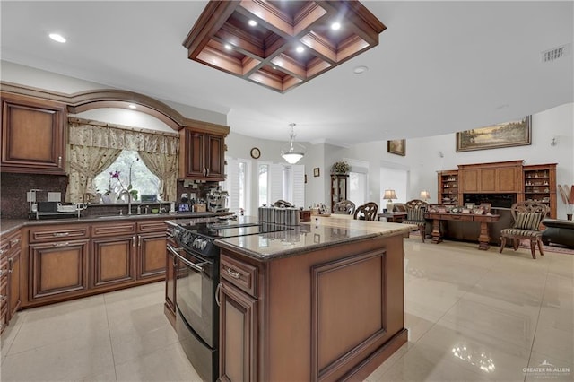 kitchen featuring black range oven, tasteful backsplash, pendant lighting, dark stone counters, and a kitchen island