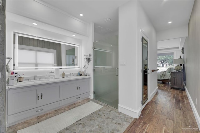 bathroom featuring hardwood / wood-style floors, vanity, and a shower with shower door