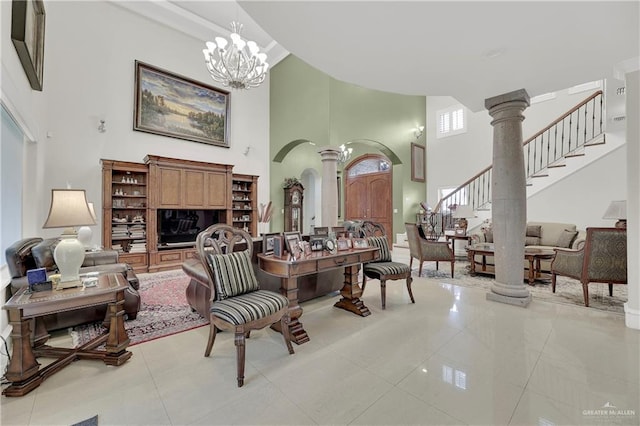 interior space featuring a chandelier, a high ceiling, and decorative columns