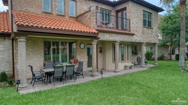 back of property with a patio area, a balcony, and a yard