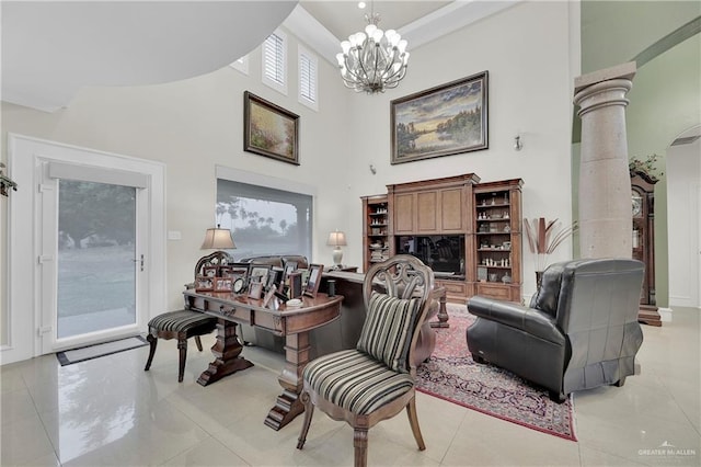 living area with a chandelier, a towering ceiling, light tile patterned floors, and decorative columns