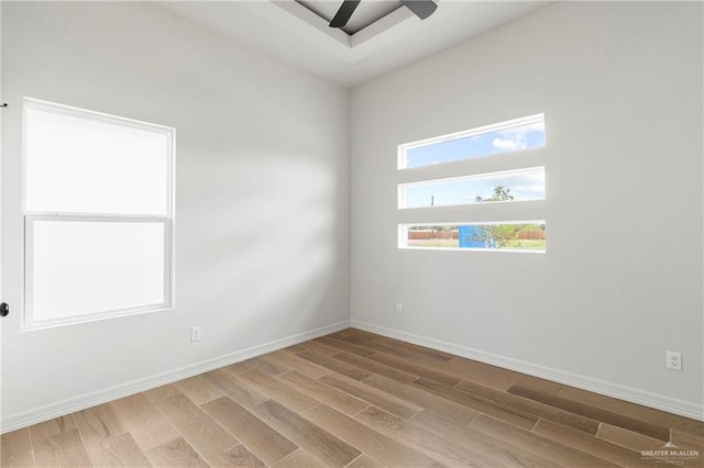 empty room featuring baseboards, ceiling fan, and wood finished floors