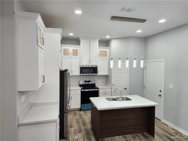 kitchen with stainless steel appliances, sink, white cabinets, dark hardwood / wood-style floors, and hanging light fixtures