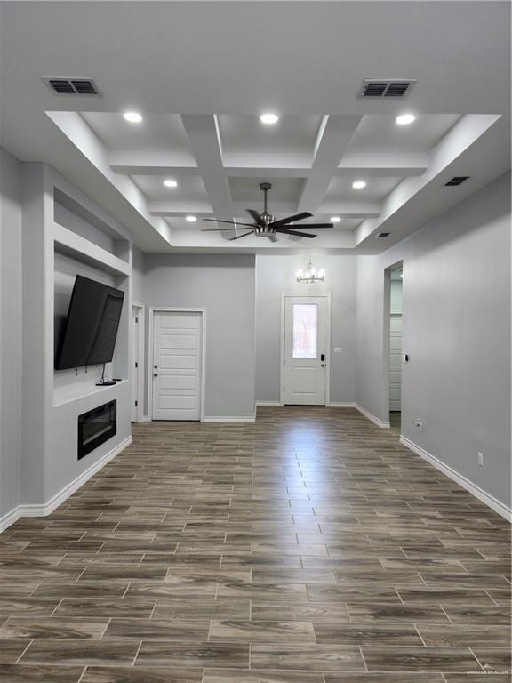 unfurnished living room featuring ceiling fan, beam ceiling, and coffered ceiling