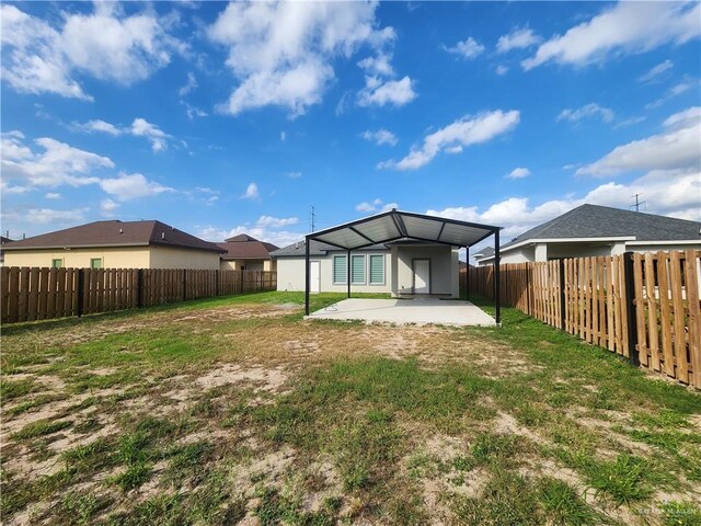 back of house featuring a lawn and a patio area