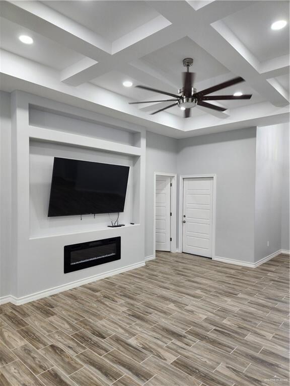 unfurnished living room with ceiling fan, hardwood / wood-style floors, and coffered ceiling