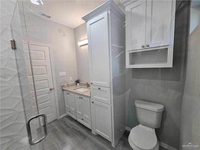 bathroom with vanity, hardwood / wood-style flooring, toilet, and an enclosed shower