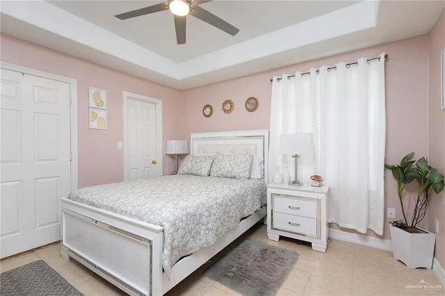 8814 S Mould Dr, Pharr, TX 78577 - bedroom featuring light tile patterned floors, baseboards, ceiling fan, and a tray ceiling