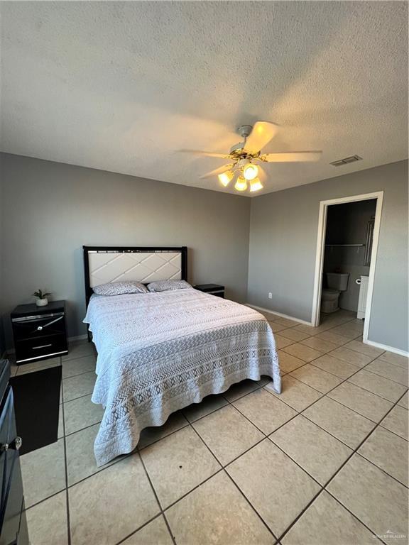 1414 Vatia Blvd, Mission, TX 78572 - bedroom with light tile patterned floors, a textured ceiling, and a ceiling fan