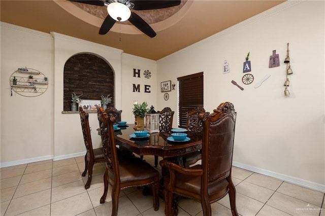 dining room with a raised ceiling, crown molding, light tile patterned floors, and ceiling fan