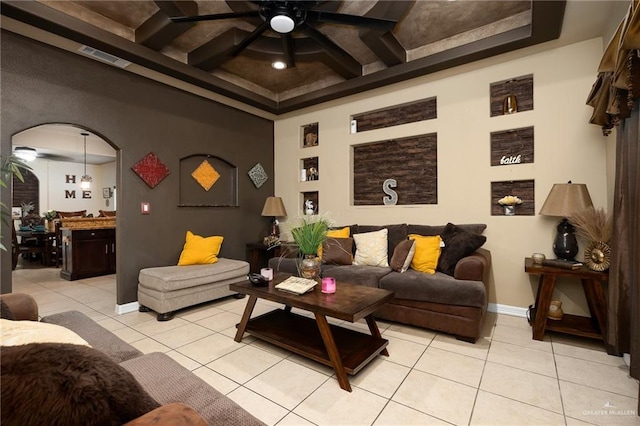 tiled living room with coffered ceiling, beam ceiling, and ceiling fan