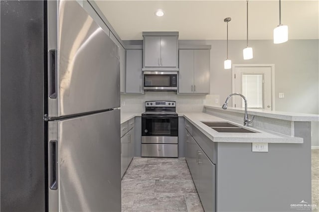 kitchen with sink, hanging light fixtures, stainless steel appliances, kitchen peninsula, and gray cabinets