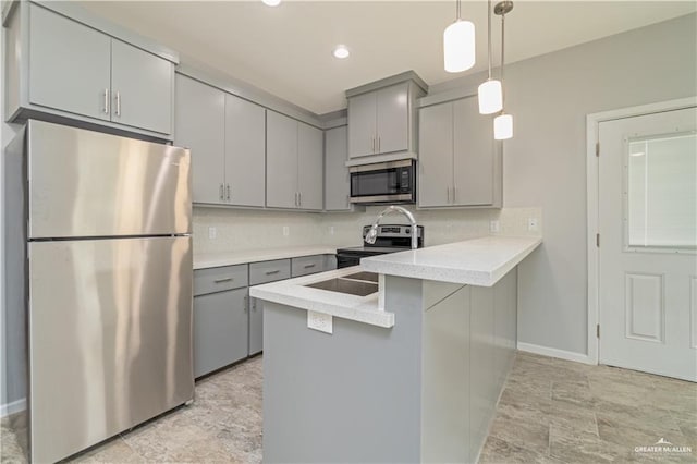 kitchen with gray cabinetry, hanging light fixtures, tasteful backsplash, kitchen peninsula, and stainless steel appliances