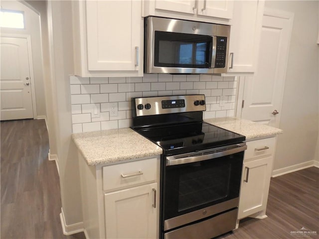 kitchen featuring backsplash, appliances with stainless steel finishes, dark wood-style flooring, and white cabinetry