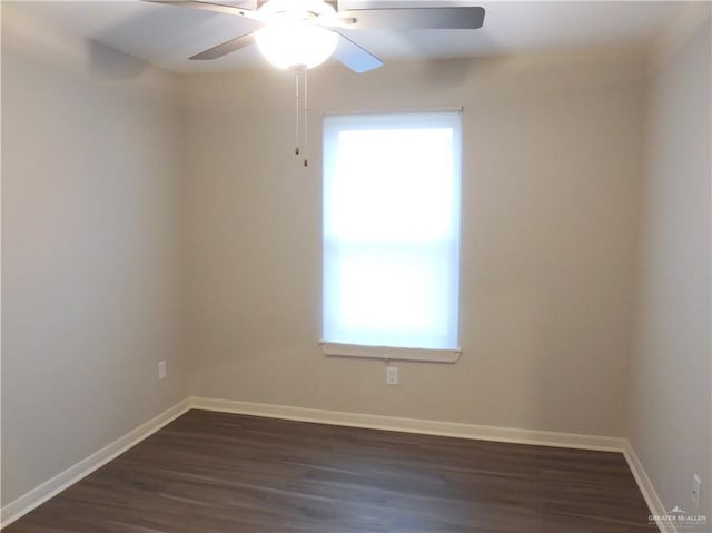 spare room featuring baseboards, ceiling fan, and dark wood-style flooring