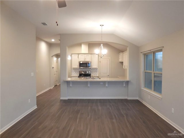 kitchen with visible vents, tasteful backsplash, stainless steel appliances, arched walkways, and white cabinets