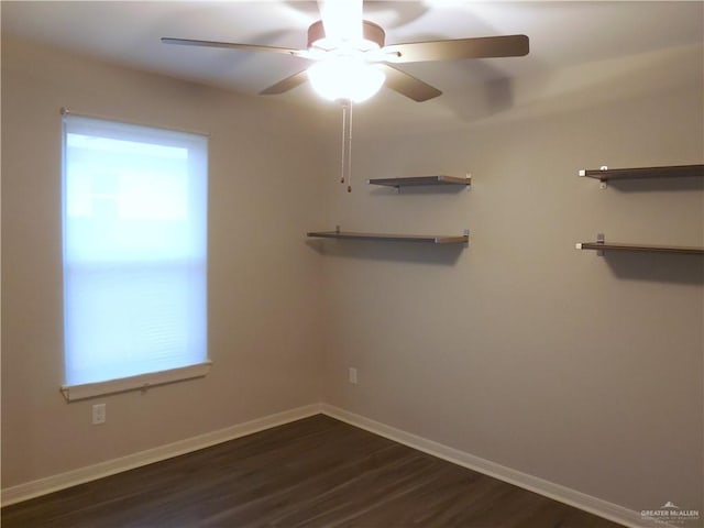 unfurnished room featuring ceiling fan, dark wood-type flooring, and baseboards