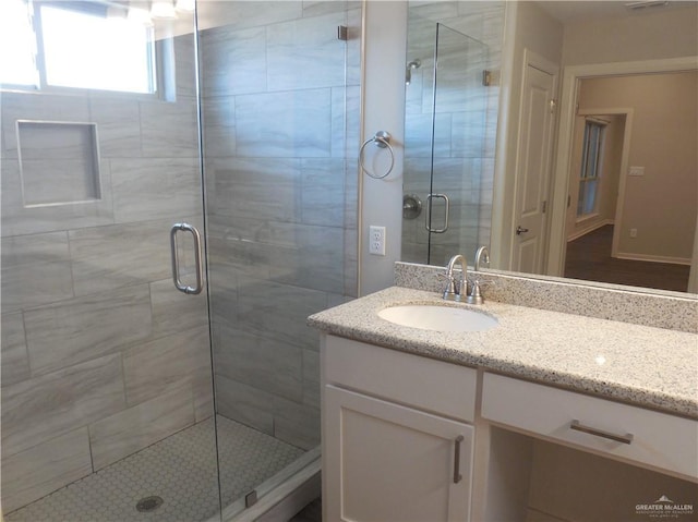 full bath with vanity and a shower stall