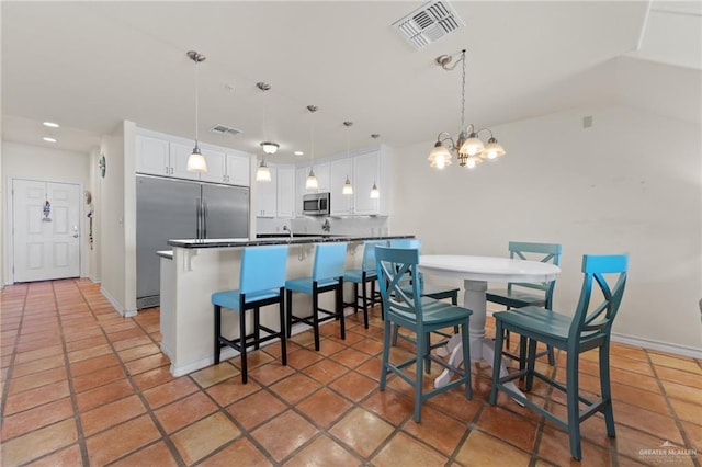 301 Houston Ave, Port Isabel, TX 78578 - kitchen with stainless steel appliances, white cabinetry, a chandelier, recessed lighting, and dark countertops