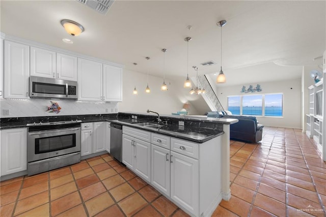 301 Houston Ave, Port Isabel, TX 78578 - kitchen featuring appliances with stainless steel finishes, a peninsula, open floor plan, and white cabinets