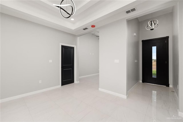 interior space featuring a notable chandelier and a tray ceiling