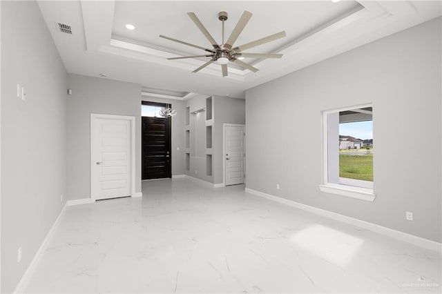 unfurnished bedroom featuring a tray ceiling and ceiling fan