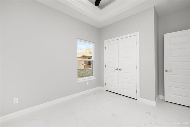 unfurnished bedroom with ceiling fan and a closet