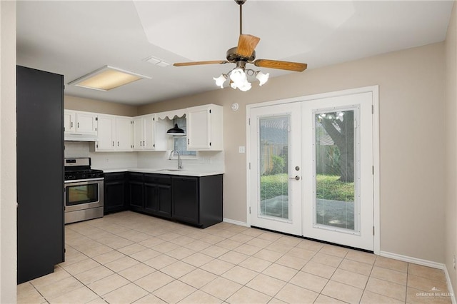 kitchen featuring ceiling fan, stainless steel range, sink, light tile patterned floors, and white cabinets