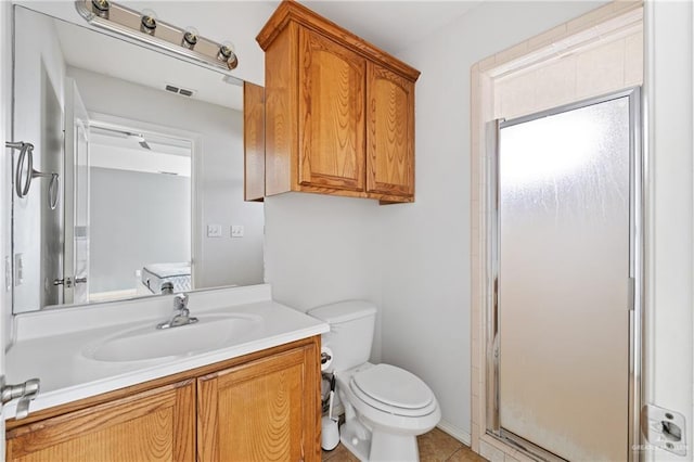 bathroom with tile patterned floors, vanity, toilet, and a shower with shower door