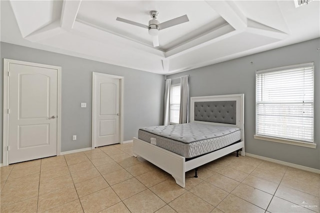 unfurnished bedroom with ceiling fan, light tile patterned flooring, and a tray ceiling