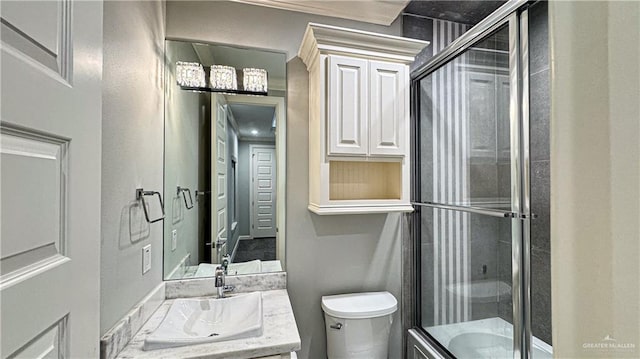 bathroom featuring a shower stall, toilet, and vanity