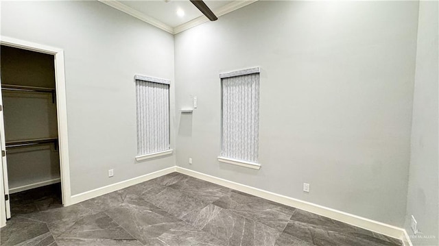 unfurnished bedroom with ornamental molding, a walk in closet, a closet, and baseboards