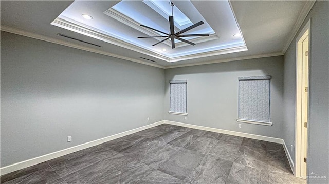 empty room featuring a ceiling fan, baseboards, a tray ceiling, and crown molding