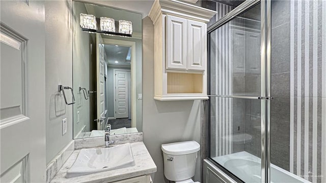 full bathroom featuring bath / shower combo with glass door, vanity, and toilet