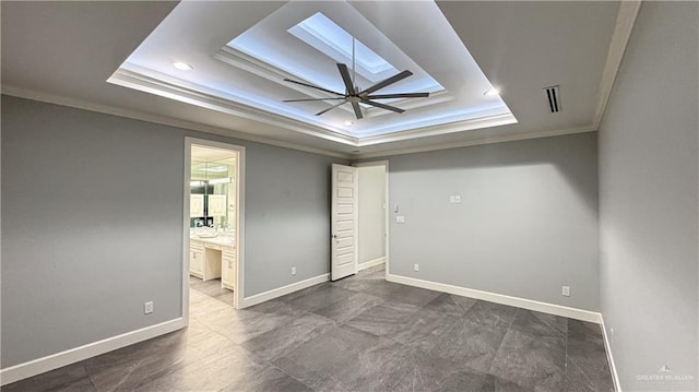 unfurnished bedroom with a skylight, baseboards, a tray ceiling, and crown molding