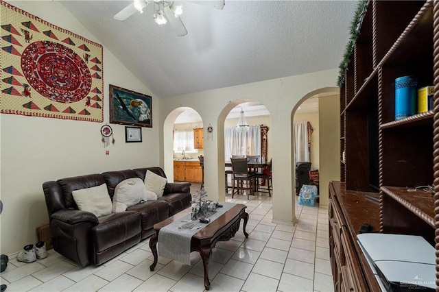 tiled living room featuring ceiling fan, a textured ceiling, and vaulted ceiling