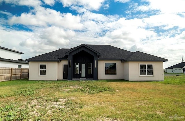 rear view of property featuring a lawn