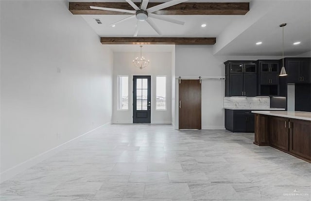 kitchen featuring beam ceiling, ceiling fan with notable chandelier, and pendant lighting