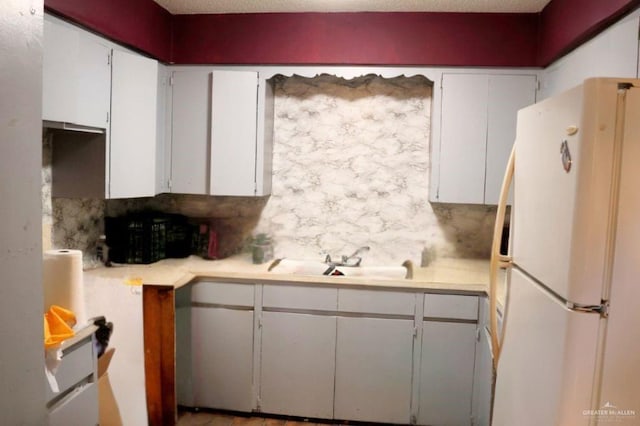 1100 Dormiendo St, Edinburg, TX 78539 - kitchen featuring freestanding refrigerator, a sink, light countertops, and white cabinetry