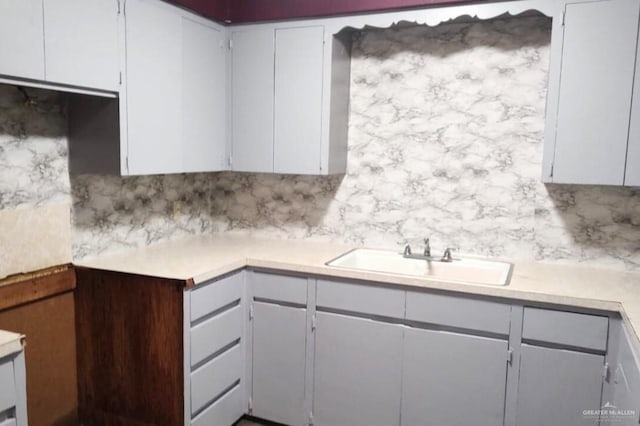 1100 Dormiendo St, Edinburg, TX 78539 - kitchen with a sink, backsplash, light countertops, and white cabinets