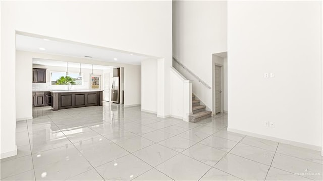 2201 Antelope Canyon St, Edinburg, TX 78541 - unfurnished living room featuring light marble finish flooring, stairs, and a high ceiling