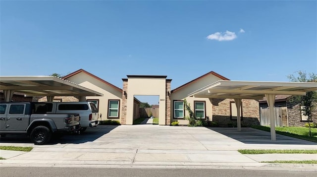 view of front facade with fence and stucco siding