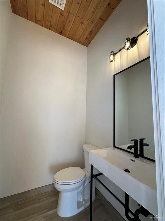 bathroom with toilet, wood-type flooring, lofted ceiling, and wood ceiling