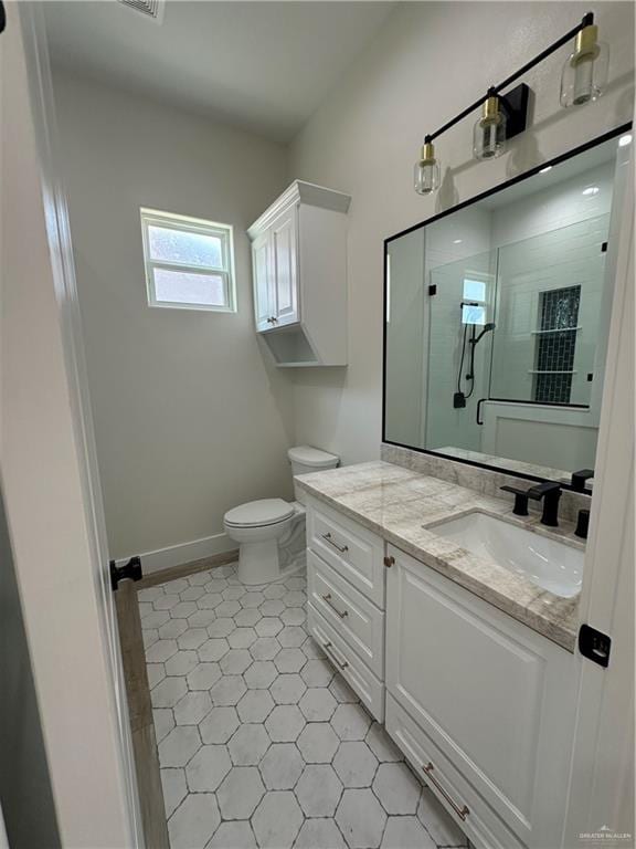 bathroom featuring vanity, toilet, and a shower with door